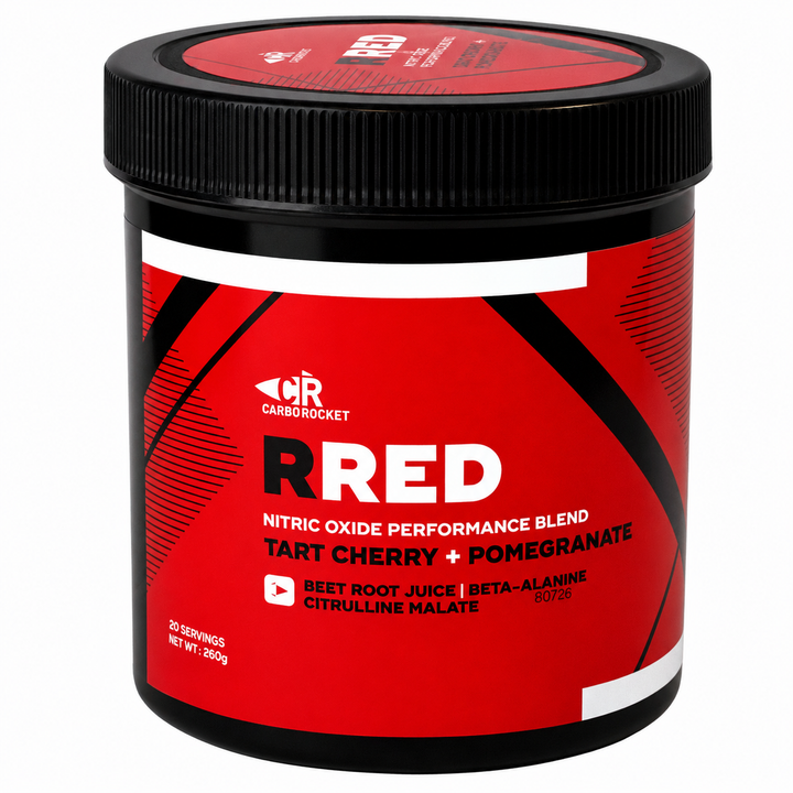 A black plastic tub of Carb Rocket RRED Nitric Oxide Performance Blend in Tart Cherry + Pomegranate flavor, featuring a bold red label with black and white graphics.